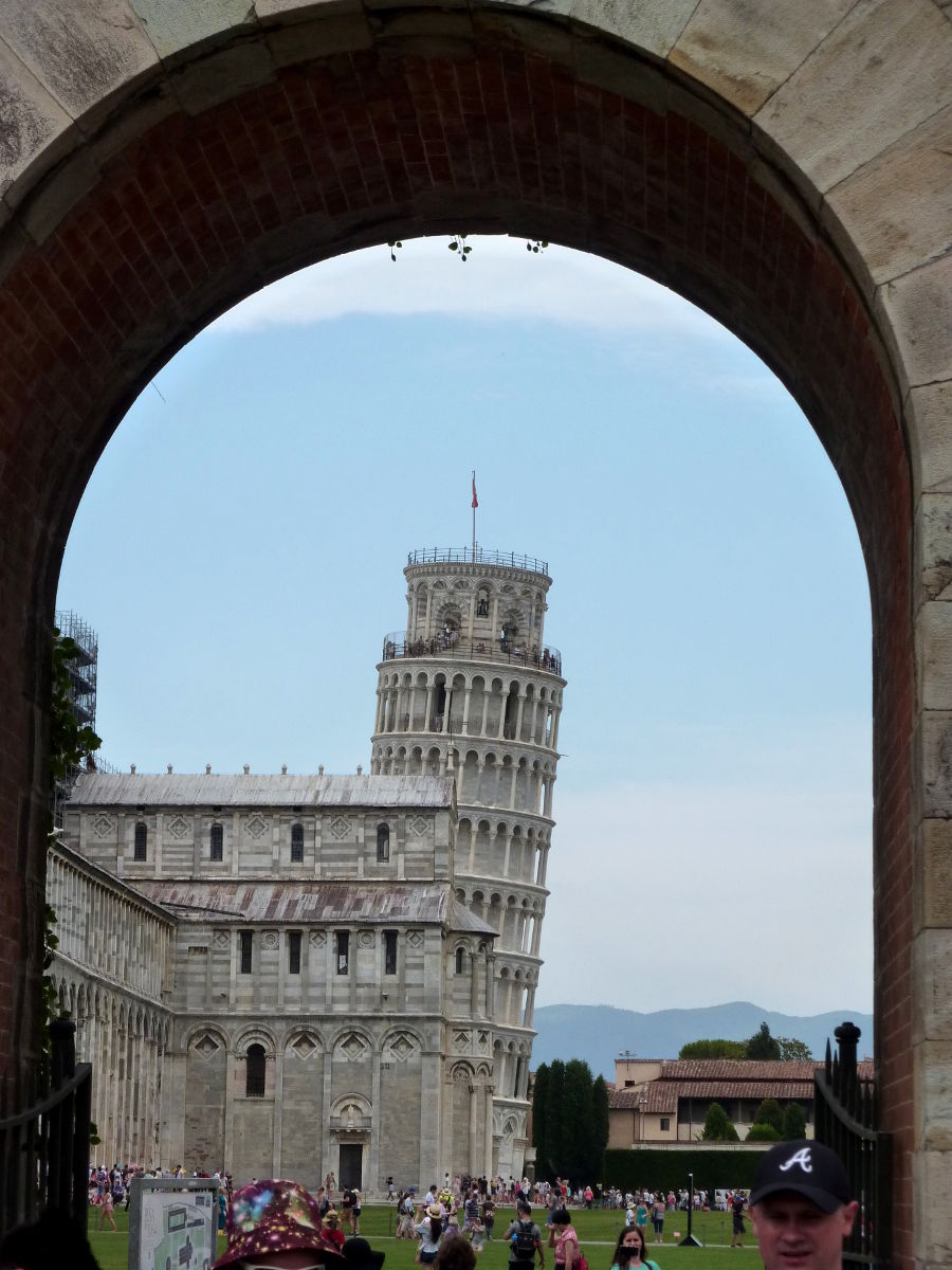 „Schiefer Turm von Pisa“ durch ein Tor der Stadtmauer fotografiert